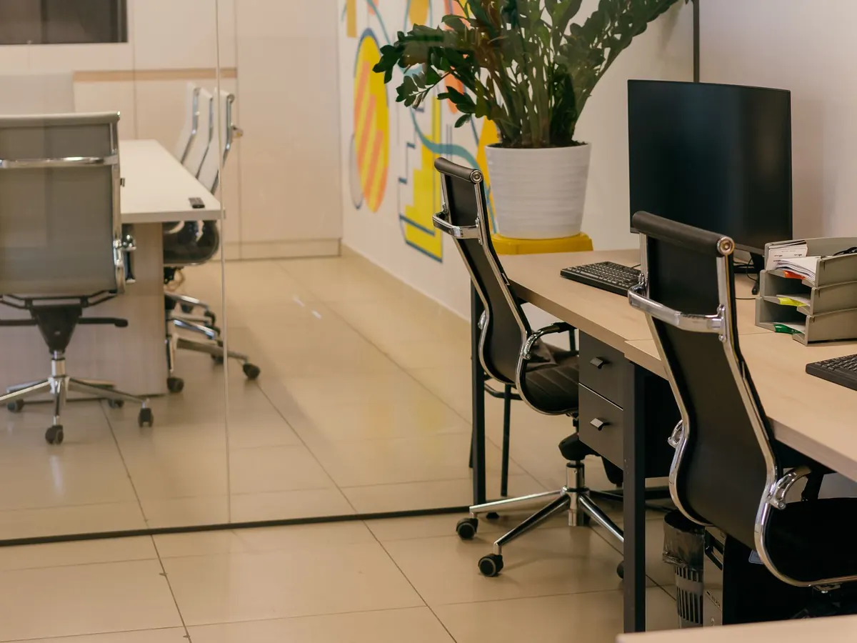 Open space de bureaux moderne, propre et lumineux, avec salle de réunion vitrée
